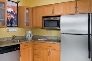 a kitchen with a refrigerator and a microwave at Residence Inn by Marriott Peoria in Peoria