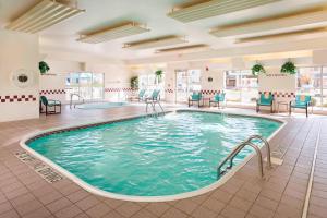 a pool in a hotel lobby with chairs and tables at Residence Inn by Marriott Peoria in Peoria