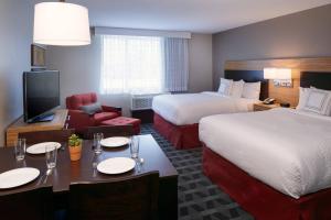 Habitación de hotel con 2 camas, mesa y sillas en TownePlace Suites by Marriott Jackson, en Jackson
