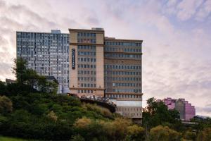 wysoki budynek z ludźmi stojącymi na moście przed nim w obiekcie Courtyard by Marriott Edmonton Downtown w mieście Edmonton