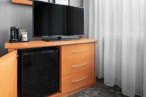 a television on top of a dresser with a dishwasher at Courtyard by Marriott Edmonton Downtown in Edmonton