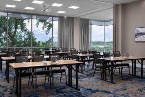 a dining room with tables and chairs and large windows at Courtyard by Marriott Edmonton Downtown in Edmonton