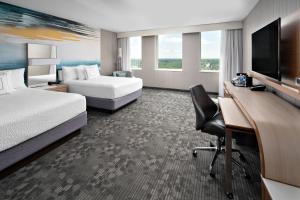 a hotel room with two beds and a desk with a computer at Courtyard by Marriott Edmonton Downtown in Edmonton