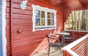 czerwony dom z dwoma krzesłami i stołem na ganku w obiekcie 2 Bedroom Amazing Home In Sderkping w mieście Söderköping