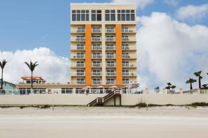 a tall yellow building with stairs in front of a beach at Residence Inn by Marriott Daytona Beach Oceanfront in Daytona Beach