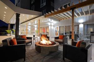 une terrasse avec un foyer extérieur, des chaises et une table. dans l'établissement TownePlace Suites by Marriott Detroit Allen Park, à Allen Park