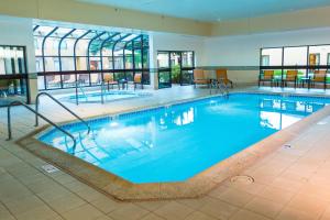 a large swimming pool with blue water in a building at Courtyard Chicago O'Hare in Des Plaines