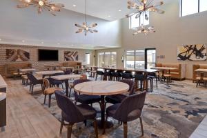 um restaurante com mesas e cadeiras e uma televisão em Fairfield Inn & Suites Las Vegas Airport South em Las Vegas