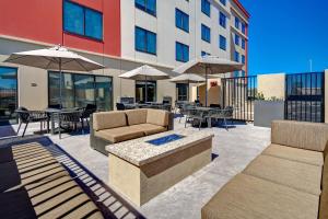 un patio con sedie, tavoli e ombrelloni di Fairfield Inn & Suites Las Vegas Airport South a Las Vegas