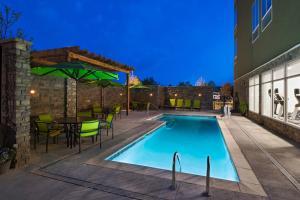 einen Pool mit einem Tisch und Stühlen sowie eine Terrasse in der Unterkunft SpringHill Suites by Marriott Denver West/Golden in Lakewood