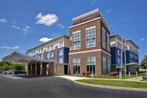 a large brick building with a car parked in a parking lot at SpringHill Suites by Marriott Indianapolis Airport/Plainfield in Plainfield