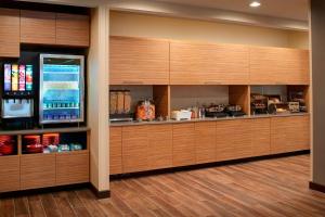a kitchen with wooden cabinets and a refrigerator at TownePlace Suites by Marriott Grand Rapids Airport in Grand Rapids