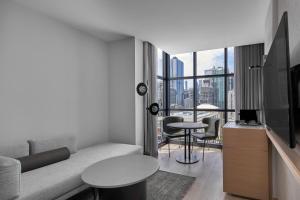 a living room with a couch and a table at Courtyard by Marriott Melbourne Flagstaff Gardens in Melbourne