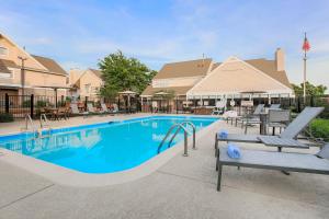 uma piscina num resort com cadeiras e um escorrega em Residence Inn Chicago Deerfield em Deerfield