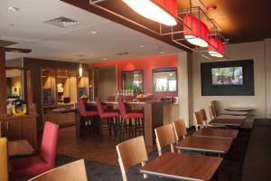 a restaurant with wooden tables and chairs and a bar at TownePlace Suites by Marriott Beaumont Port Arthur in Port Arthur