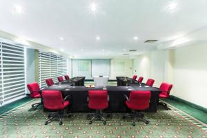 トルーカにあるCourtyard Toluca Airportの大きなテーブルと赤い椅子が備わる会議室を利用できます。
