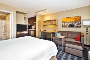 TownePlace Suites Republic Airport Long Island Farmingdale في فارمينغديل: غرفه فندقيه بسرير واريكه