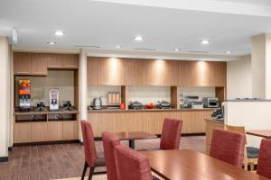 una sala de conferencias con mesas y sillas y una cocina en TownePlace Suites Cincinnati Fairfield, en Fairfield