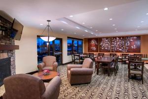 a lobby with a waiting room with tables and chairs at TownePlace Suites by Marriott Billings in Billings