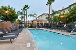 a swimming pool with lounge chairs next to a hotel at Residence Inn Los Angeles LAX/El Segundo in El Segundo