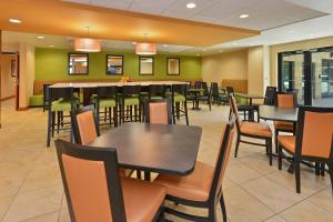 ein Restaurant mit Tischen und Stühlen und eine Bar in der Unterkunft Fairfield Inn & Suites by Marriott Denver Aurora/Parker in Aurora