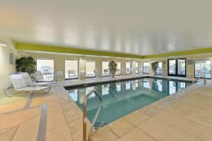 a swimming pool in a building with chairs and tables at Fairfield Inn & Suites by Marriott Denver Aurora/Parker in Aurora