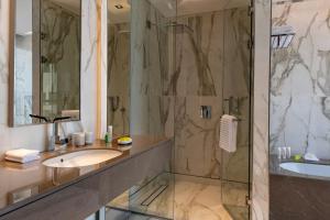 a bathroom with a sink and a shower at Agora, Doha, Autograph Collection in Doha