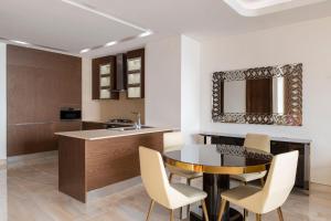 a kitchen with a table and chairs and a sink at Agora, Doha, Autograph Collection in Doha