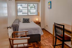 Habitación pequeña con cama y ventana en Apartamento en el centro de Pocitos en Montevideo