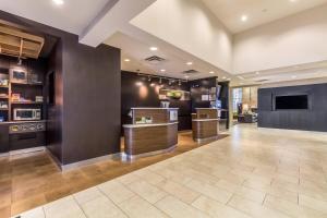 a large room with a kitchen with counters and a tv at Courtyard Dallas DFW Airport South/Irving in Irving
