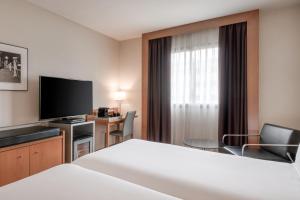 A bed or beds in a room at AC Hotel Sevilla Fórum by Marriott