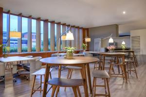 a restaurant with tables and chairs and windows at AC Hotel Sevilla Fórum by Marriott in Seville