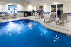 Fairfield by Marriott Ruston في روستون: مسبح في غرفة الفندق مع كراسي وطاولة