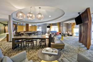 a hotel lobby with a dining and living room at SpringHill Suites Lexington Near the University of Kentucky in Lexington