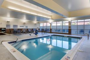 una piscina con mesas y sillas en un edificio en Fairfield by Marriott Inn & Suites Sandusky en Sandusky