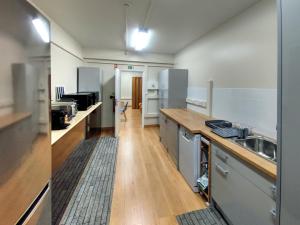 阿托吉亞達巴萊亞的住宿－Blue Ocean Guesthouse，厨房铺有木地板,配有白色橱柜。