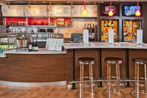 a bar in a restaurant with stools at Courtyard by Marriott Frederick in Frederick