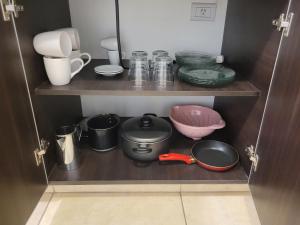 un armario lleno de muchos utensilios de cocina en La vista, departamento cómodo y acogedor en Salta
