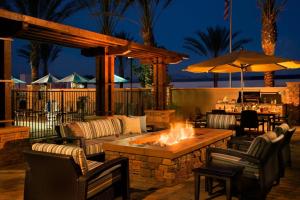 a patio with a fire pit with chairs and tables at Residence Inn By Marriott Port Arthur in Port Arthur