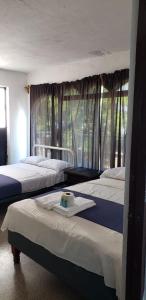 una camera da letto con tre letti e una finestra di Casa Costa Brava ad Acapulco