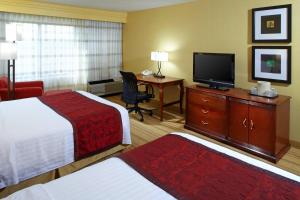 a hotel room with two beds and a flat screen tv at Courtyard Altoona in Altoona