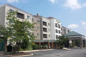 a building on a street with a parking lot at Courtyard Altoona in Altoona