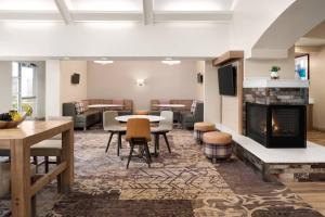 a lobby with a fireplace and a table and chairs at Residence Inn Atlanta Gwinnett Place in Duluth