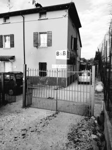 ein Zaun vor einem Haus mit einem Gebäude in der Unterkunft B&B Porte Rosse in Solferino