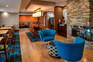 a restaurant with blue chairs and a fireplace at Fairfield Inn by Marriott Richmond in New Paris