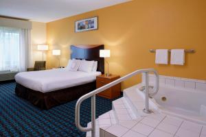 a hotel room with a bed and a bath tub at Fairfield Inn by Marriott Richmond in New Paris