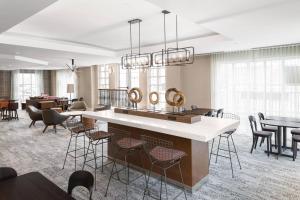 a lobby with a bar and tables and chairs at Courtyard by Marriott Charlottesville - University Medical Center in Charlottesville