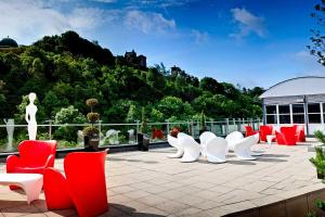 a group of white and red chairs on a patio at The Glasshouse, Autograph Collection in Edinburgh