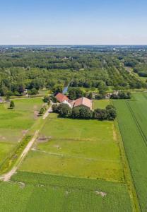 een luchtzicht op een groot groen veld met een huis bij byTilch in Borgercompagnie