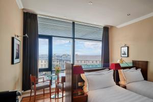 a hotel room with two beds and a table and a window at The Glasshouse, Autograph Collection in Edinburgh